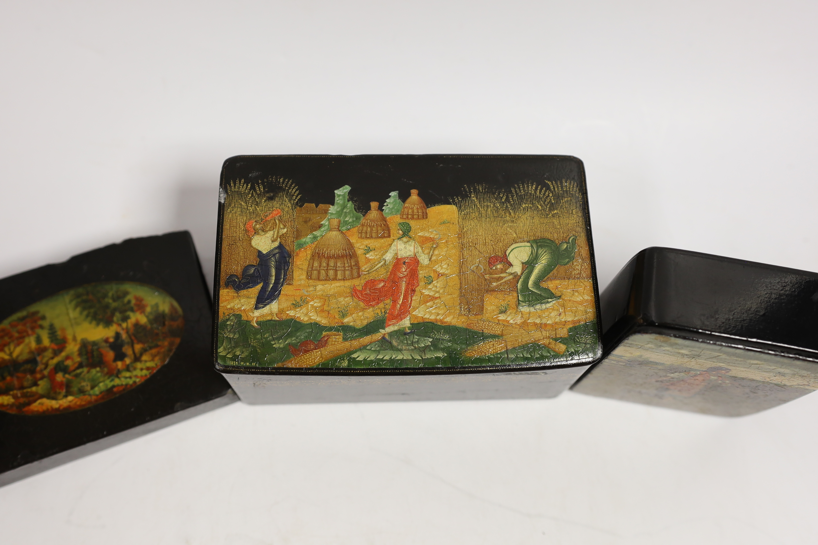 Four Russian lacquer boxes and a similar napkin ring, Palekh and others, the oval box painted with figures from legend and the others with rural scenes, some inscribed with the subject or artist, largest 13.7cm wide (5)